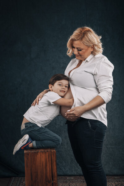 Φωτογραφία εγκύου με μικρό αγόρι να την αγκαλιάζει