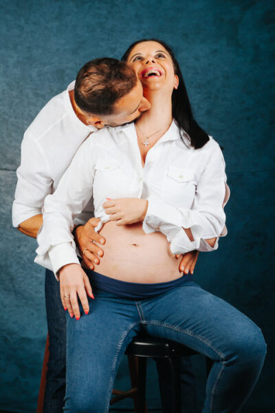 ζευγάρι άνδρας γυναίκα, αγκαλιά, ο άνδρας φιλάει τη γυναίκα στο λαιμό η γυναίκα είναι έγκυος