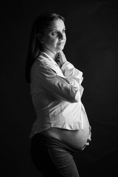 Έγκυος με λευκό πουκάμισο σε ασπρόμαυρη καλλιτεχνική φωτογραφία