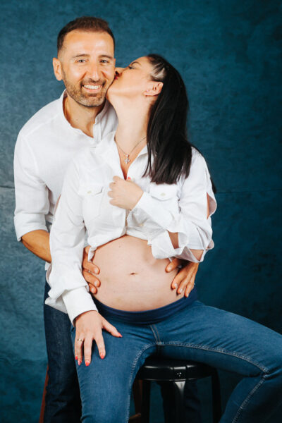 ζευγάρι άνδρας γυναίκα, αγκαλιά χαμογελαστοί στο φακό η γυναίκα είναι έγκυος